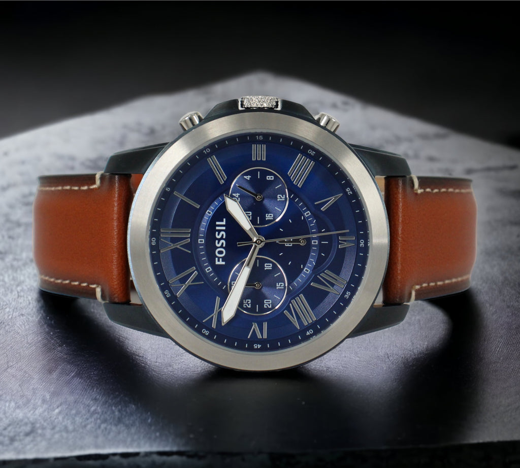  Deze mooie Fossil Grant FS5151 Herenhorloge, chronograaf heeft een blauwe ion-gecoate roestvrijstalen behuizing met een bruin leren band. Verkrijgbaar bij Optiwatch